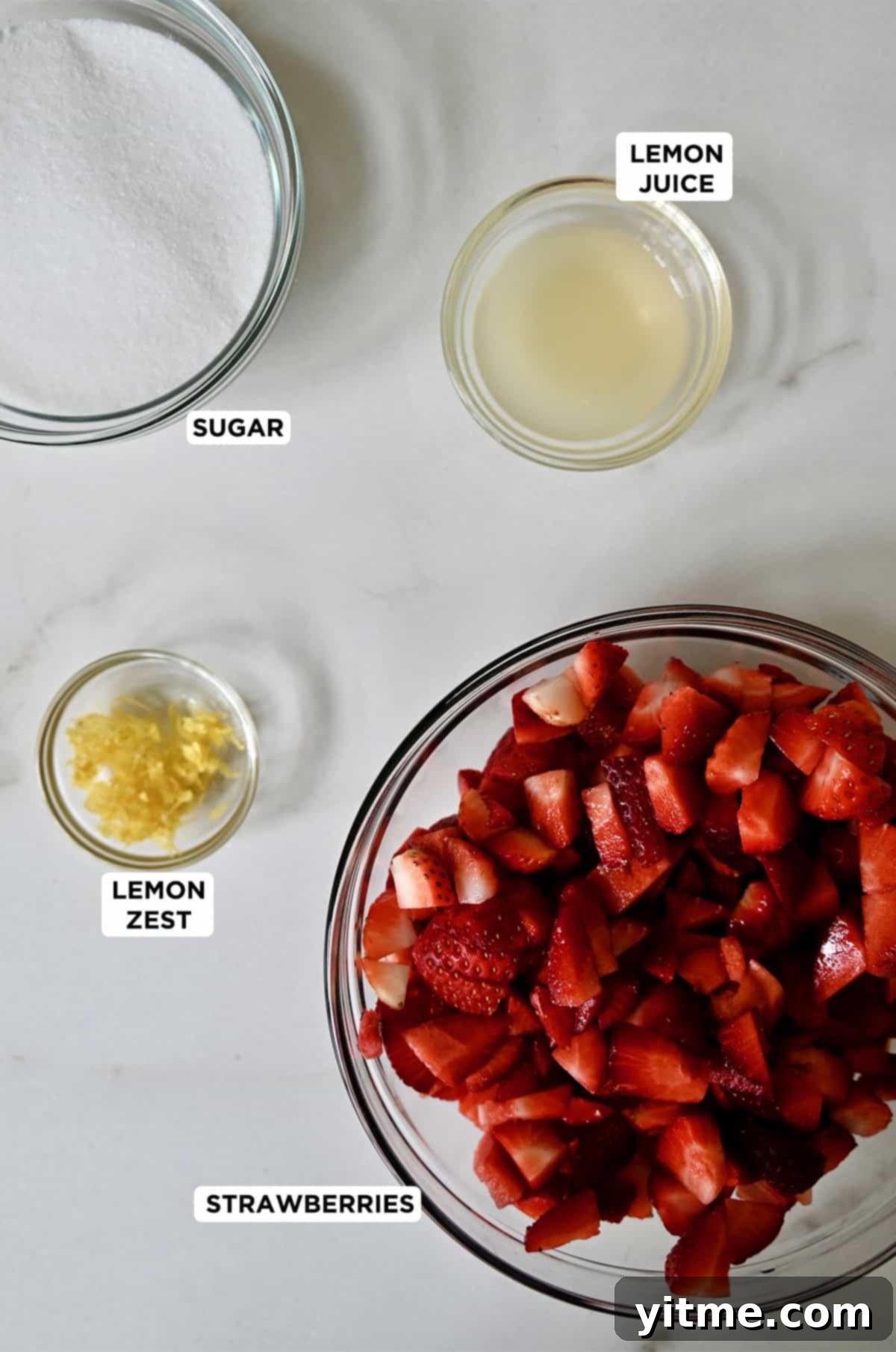 The four essential ingredients for homemade strawberry sauce: fresh strawberries, granulated sugar, fresh lemon juice, and aromatic lemon zest.