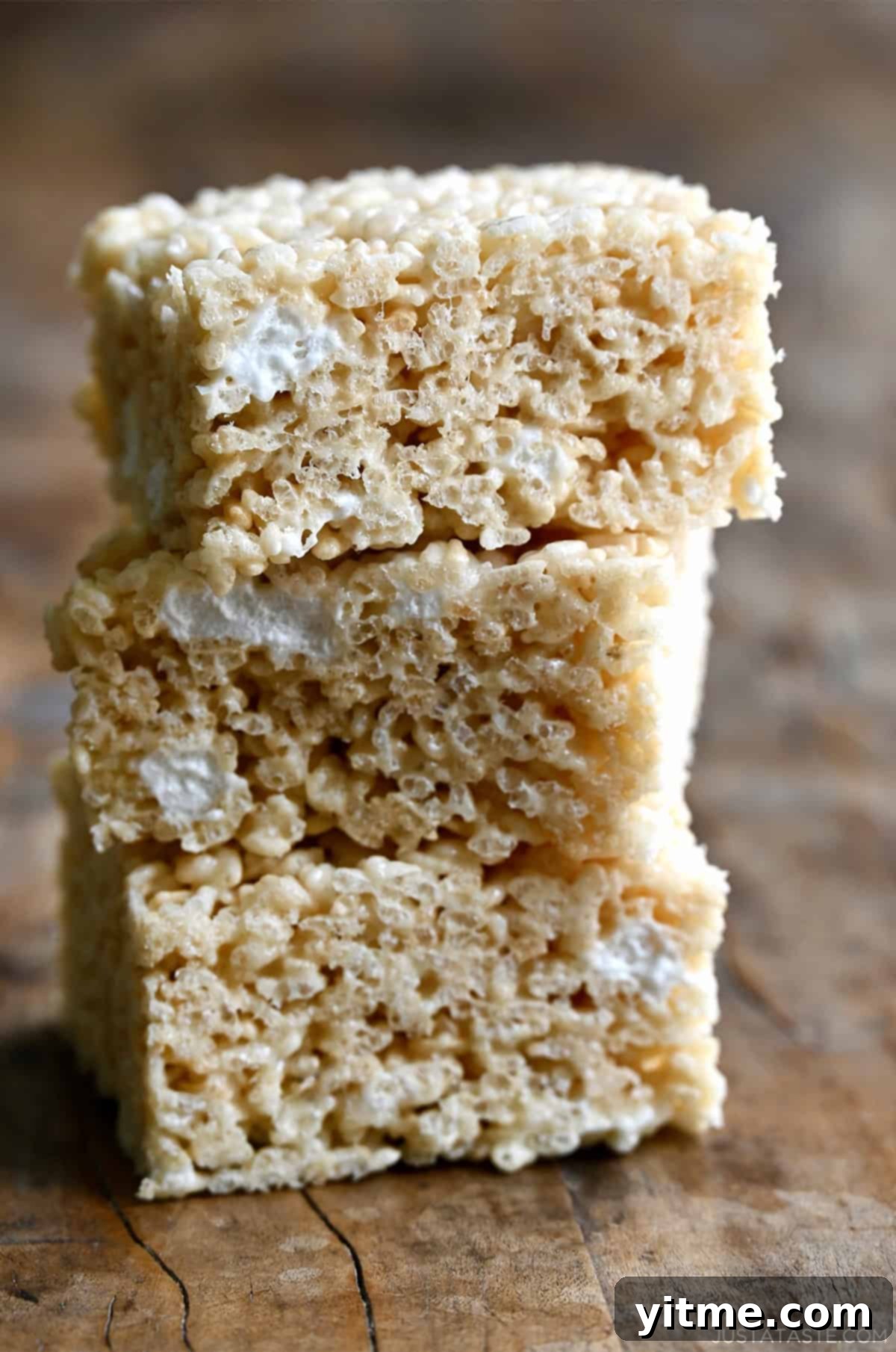 Three extra-gooey homemade Rice Krispie Treats piled atop each other.