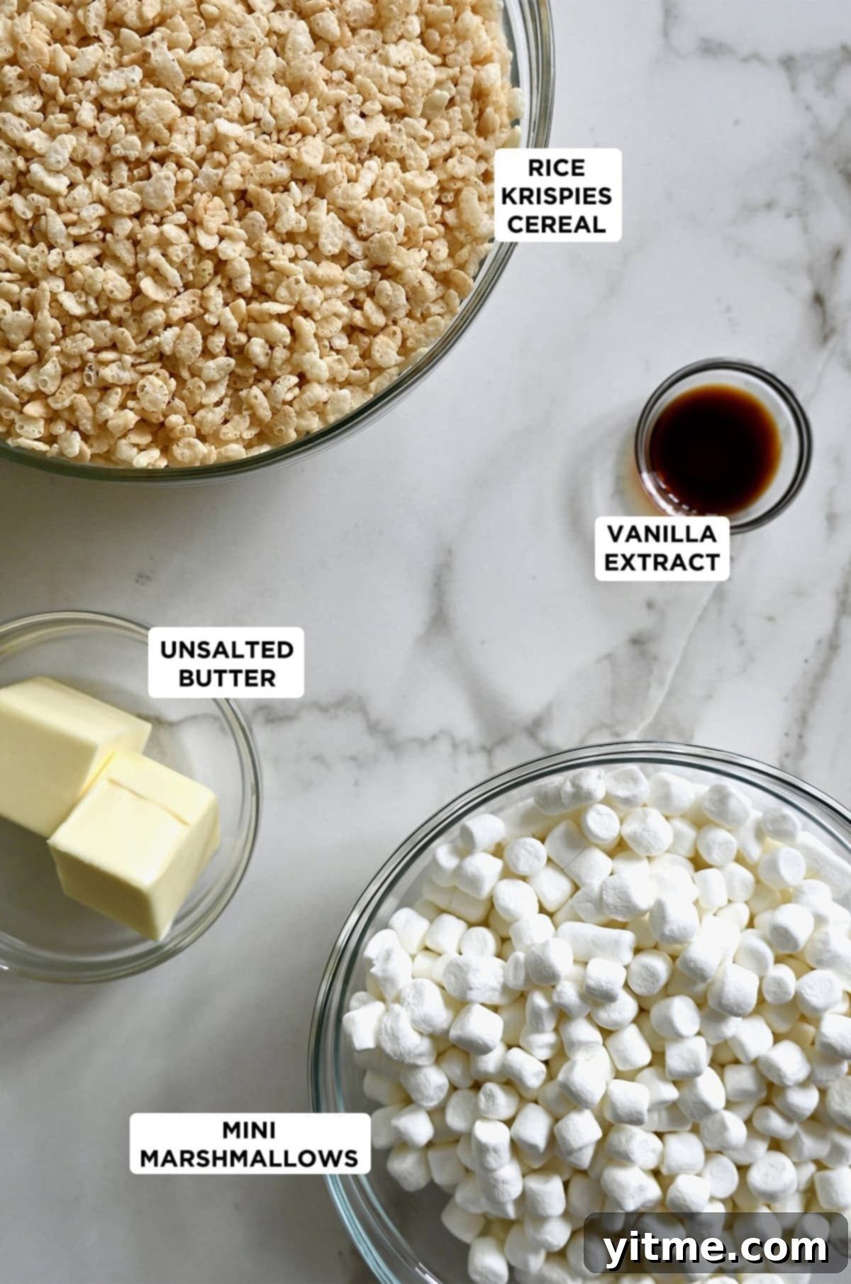 The four ingredients needed to make Rice Krispie Treats: crispy rice cereal, mini marshmallows, butter and vanilla extract.