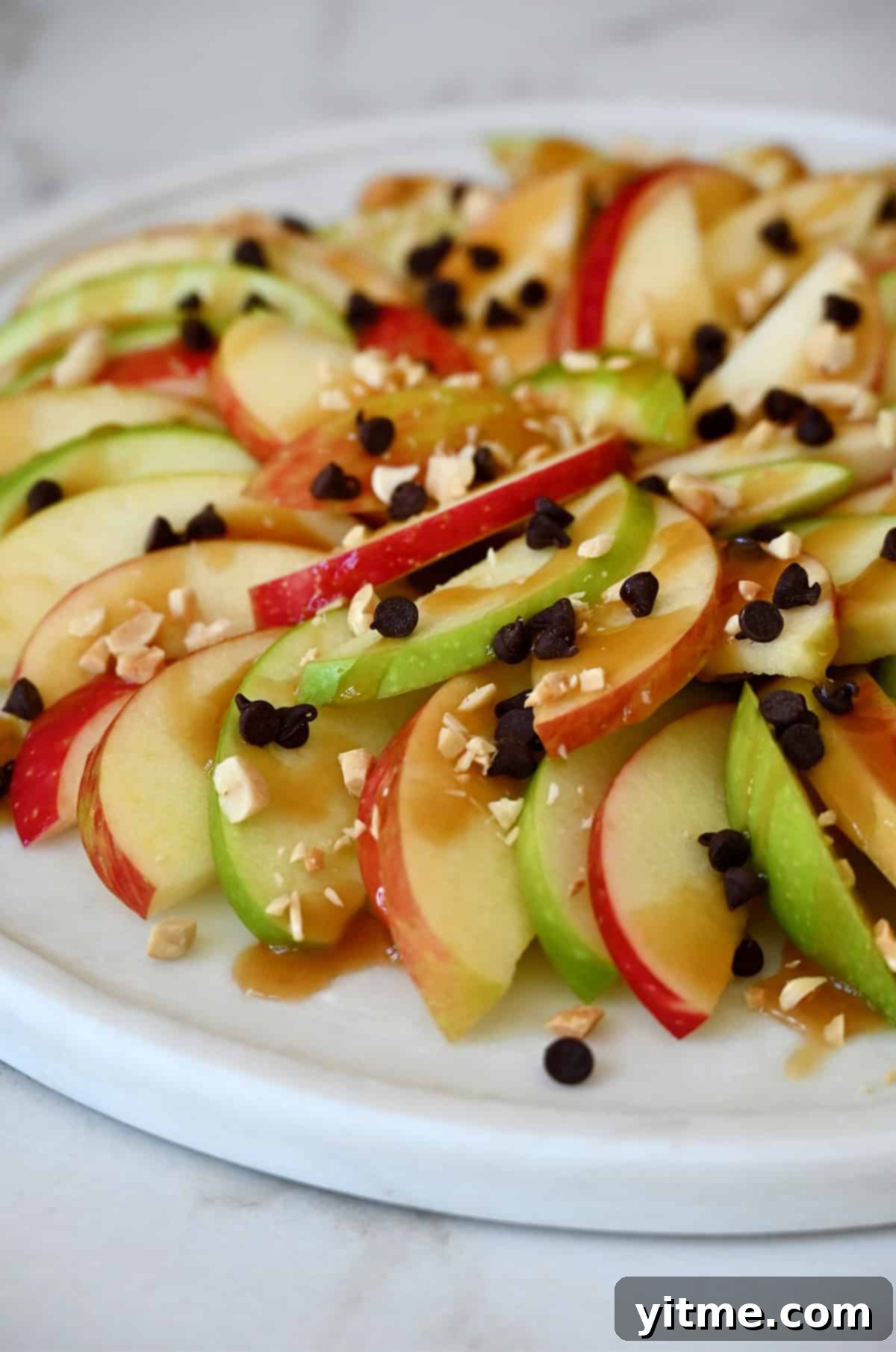 Apple nachos with caramel sauce, mini chocolate chips, and crushed peanuts.