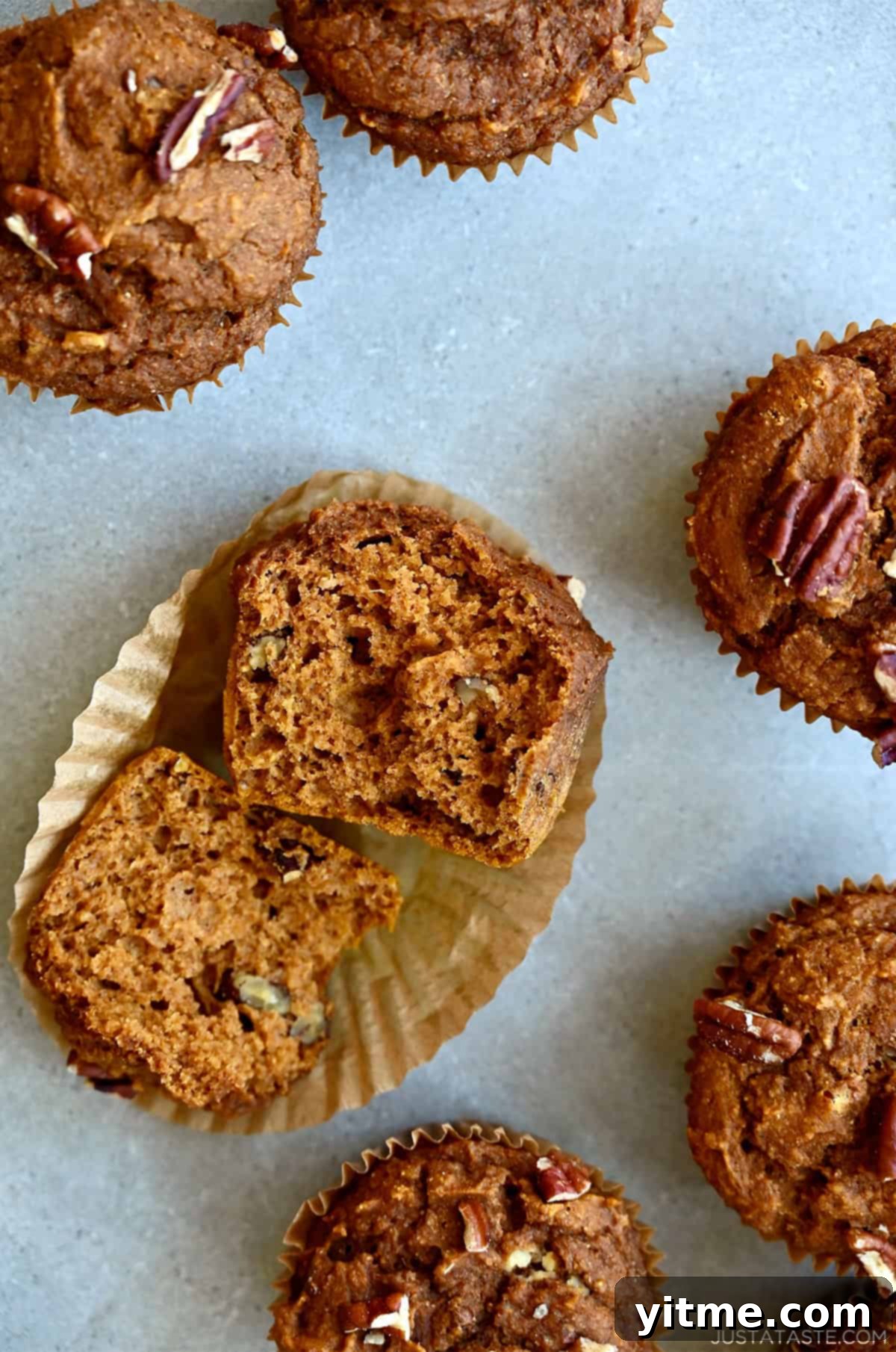Wholesome Pumpkin Delights 11 A halved pumpkin muffin with pecans, revealing a moist and tender center, highlighting the perfect texture and flavor.