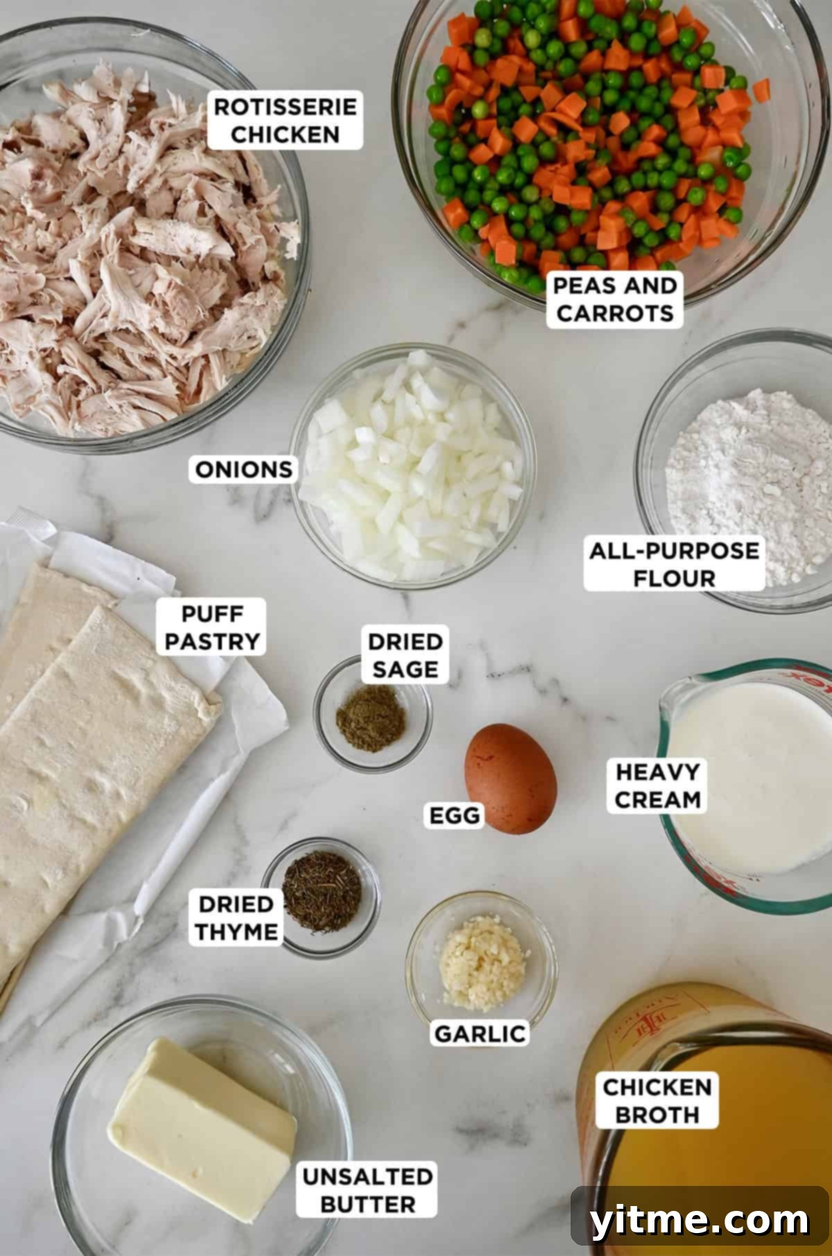Ingredients to make chicken pot pie with frozen puff pastry and rotisserie chicken in various sizes of glass bowls.