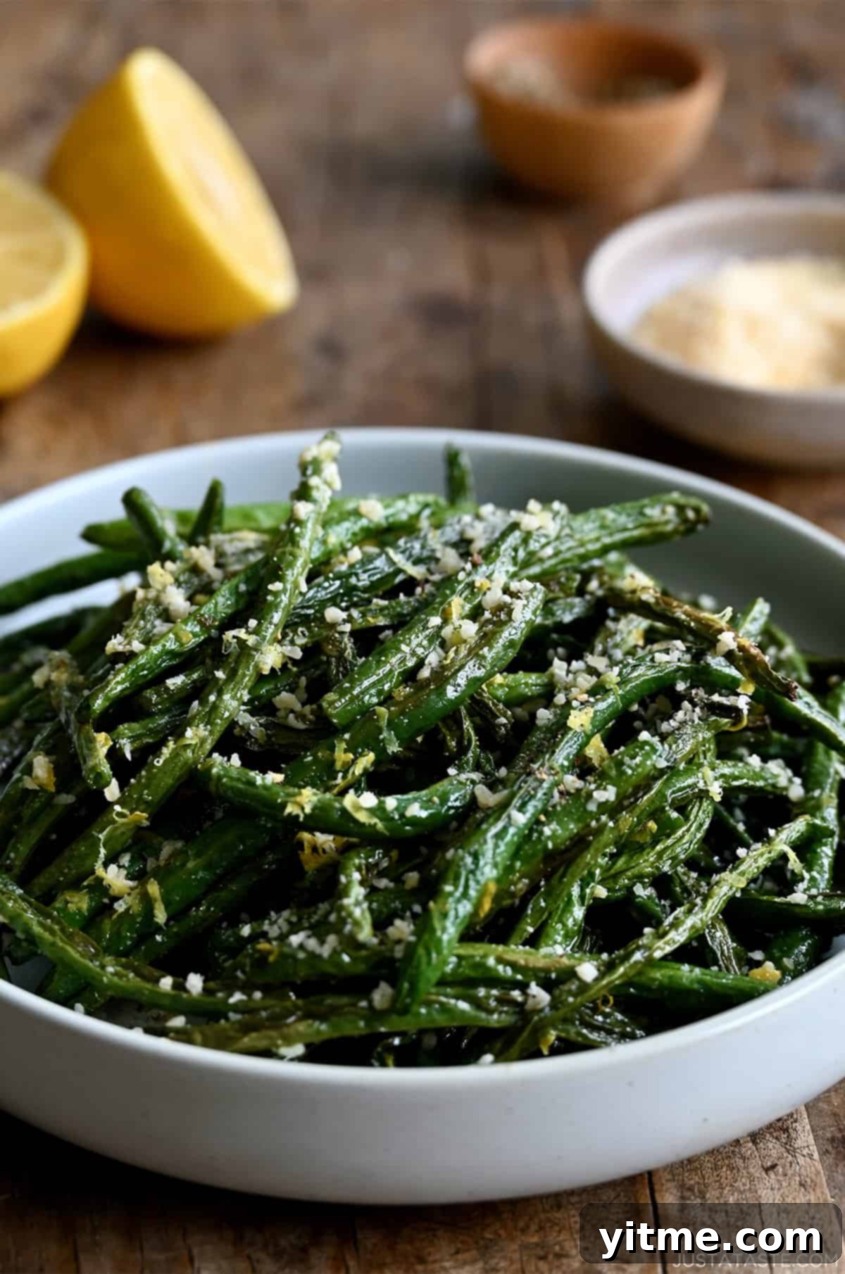 Roasted green beans with grated Parmesan in a serving bowl.