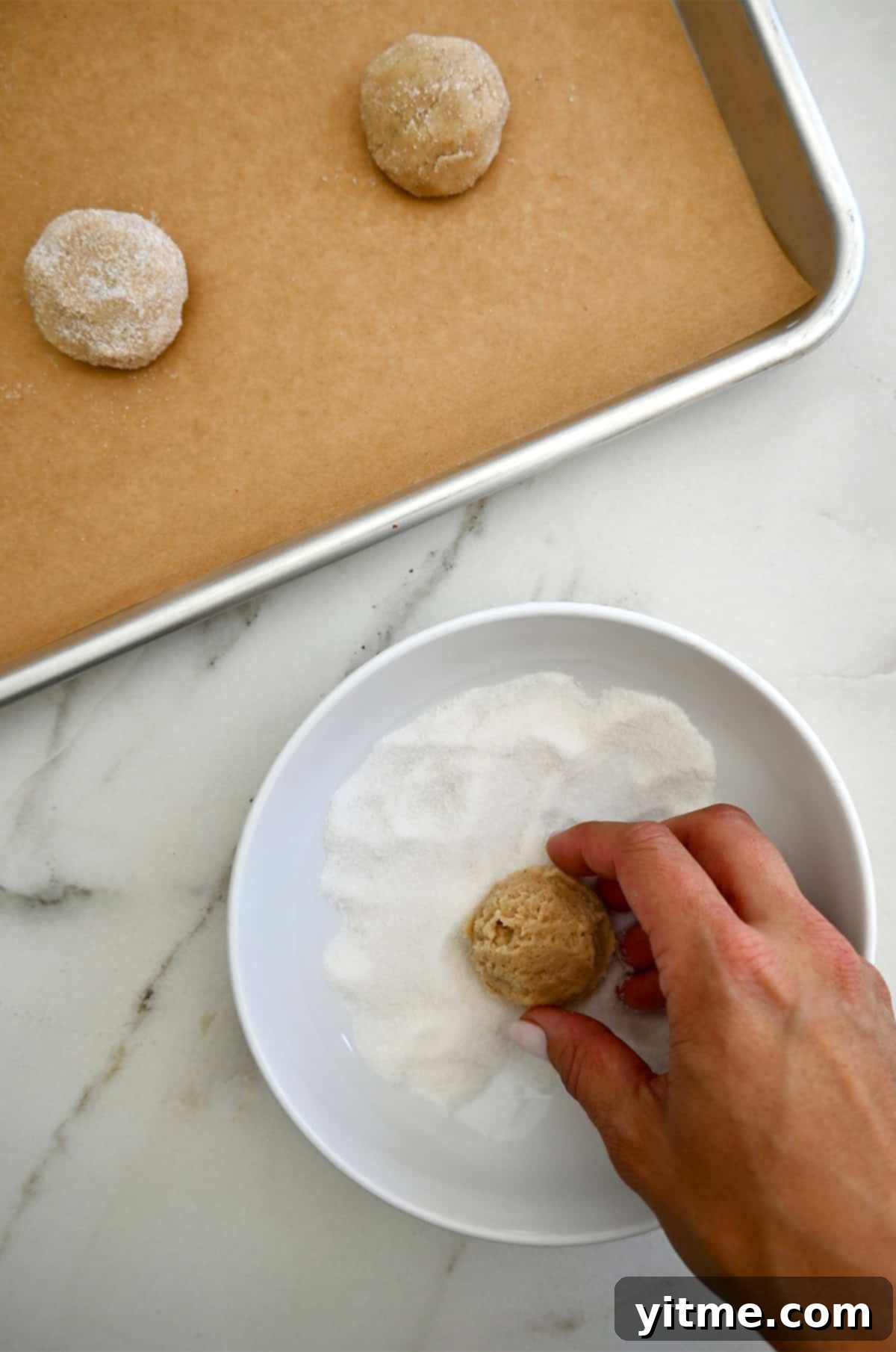 Rolling chai cookie dough balls in sugar.