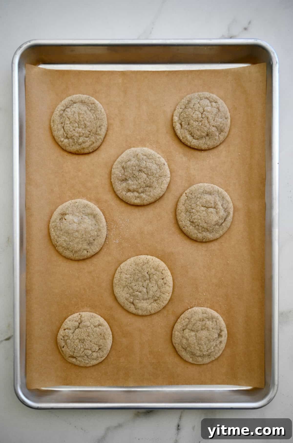 Baked chai cookies cooling on a baking sheet.
