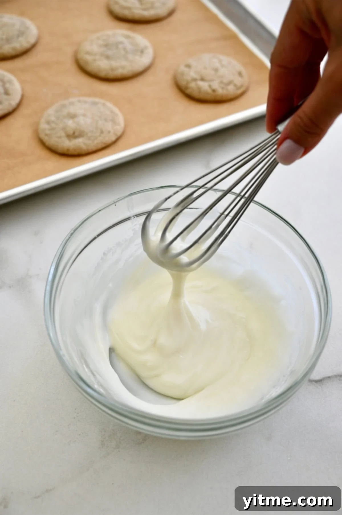 Eggnog icing in a bowl with chai cookies.