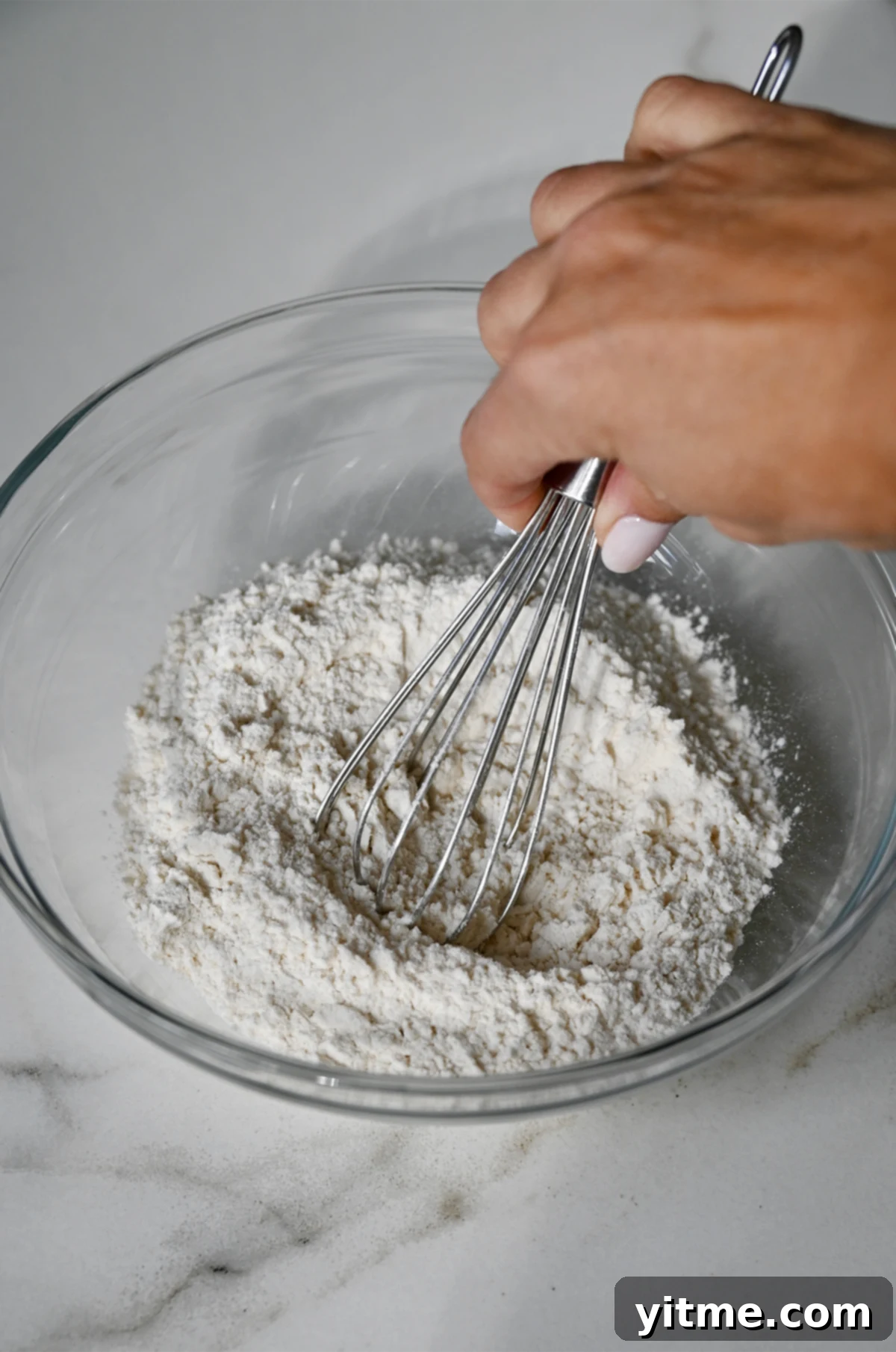 Whisking together dry ingredients in a bowl.