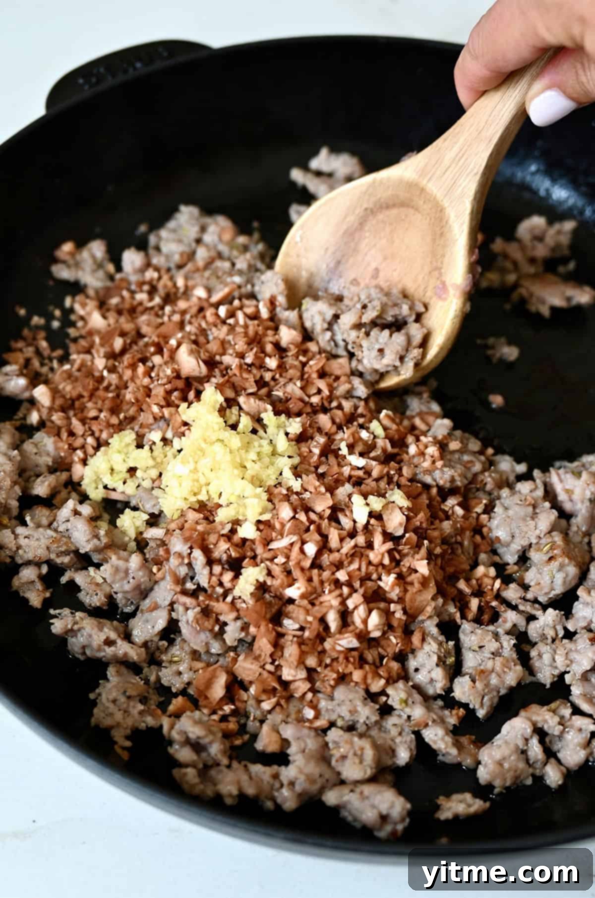 Sausage-Kissed Mushroom Bites 8 Adding mushroom stems and garlic