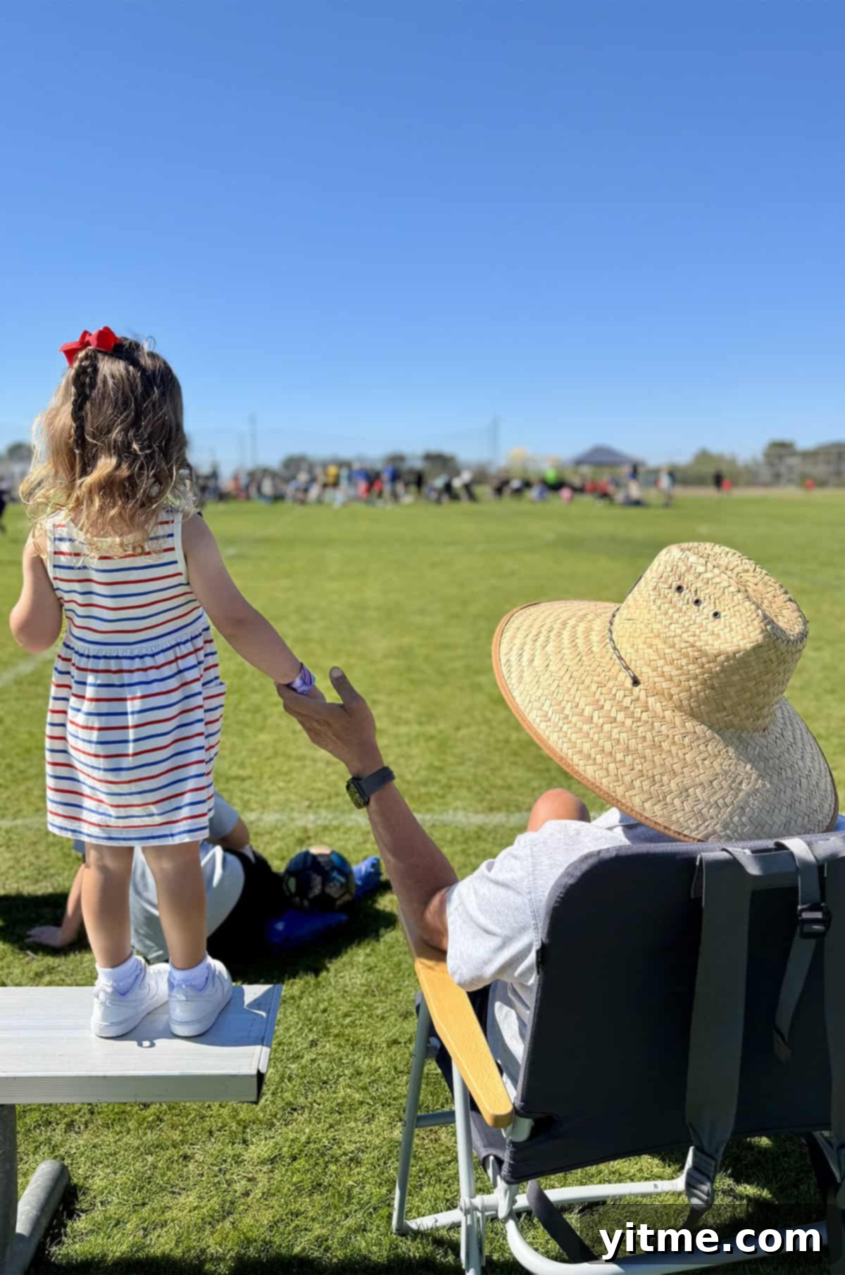 Granddaughter and grandpa together on a soccer field