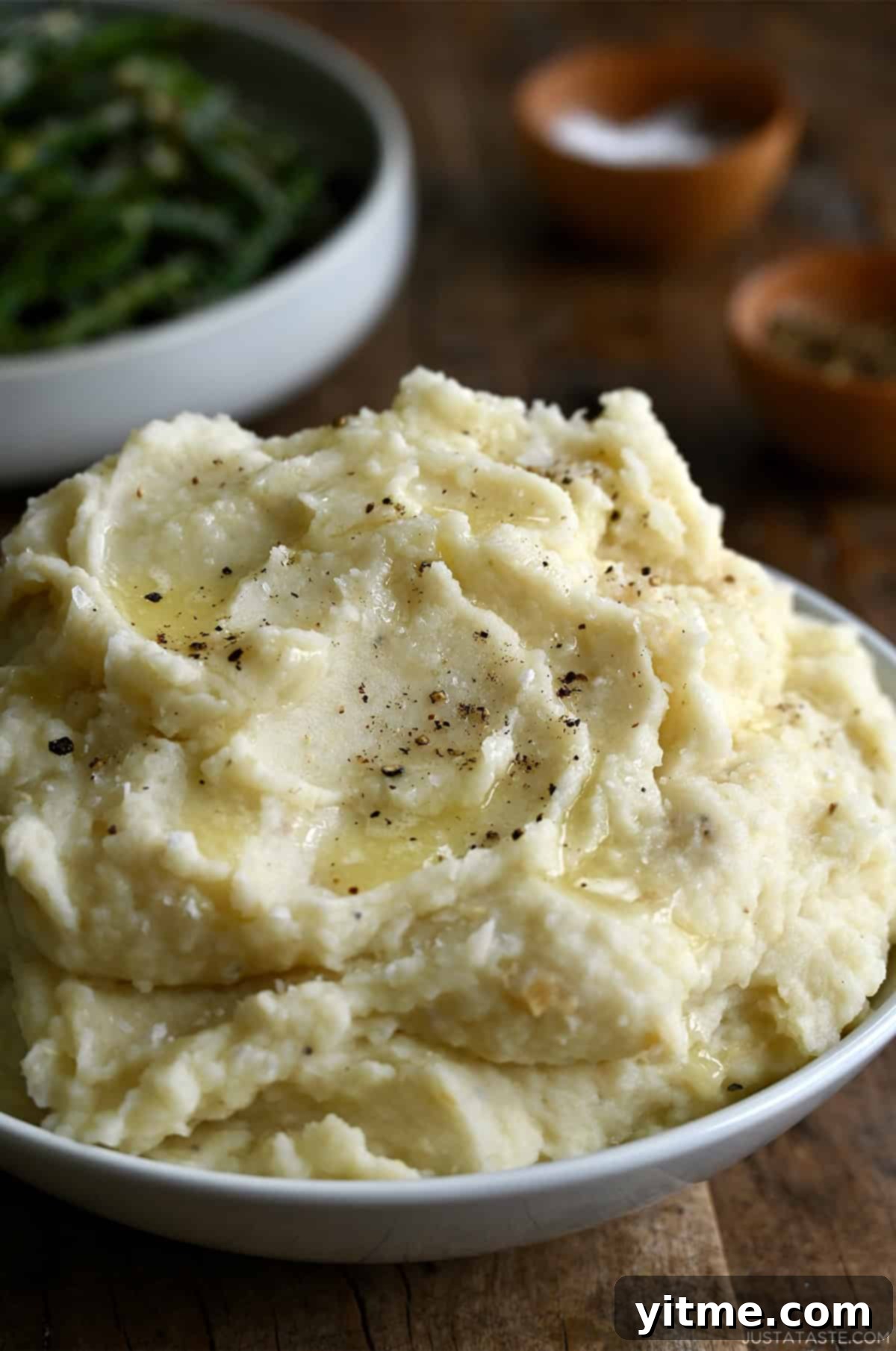 Creamy roasted garlic mashed potatoes served in a white bowl.