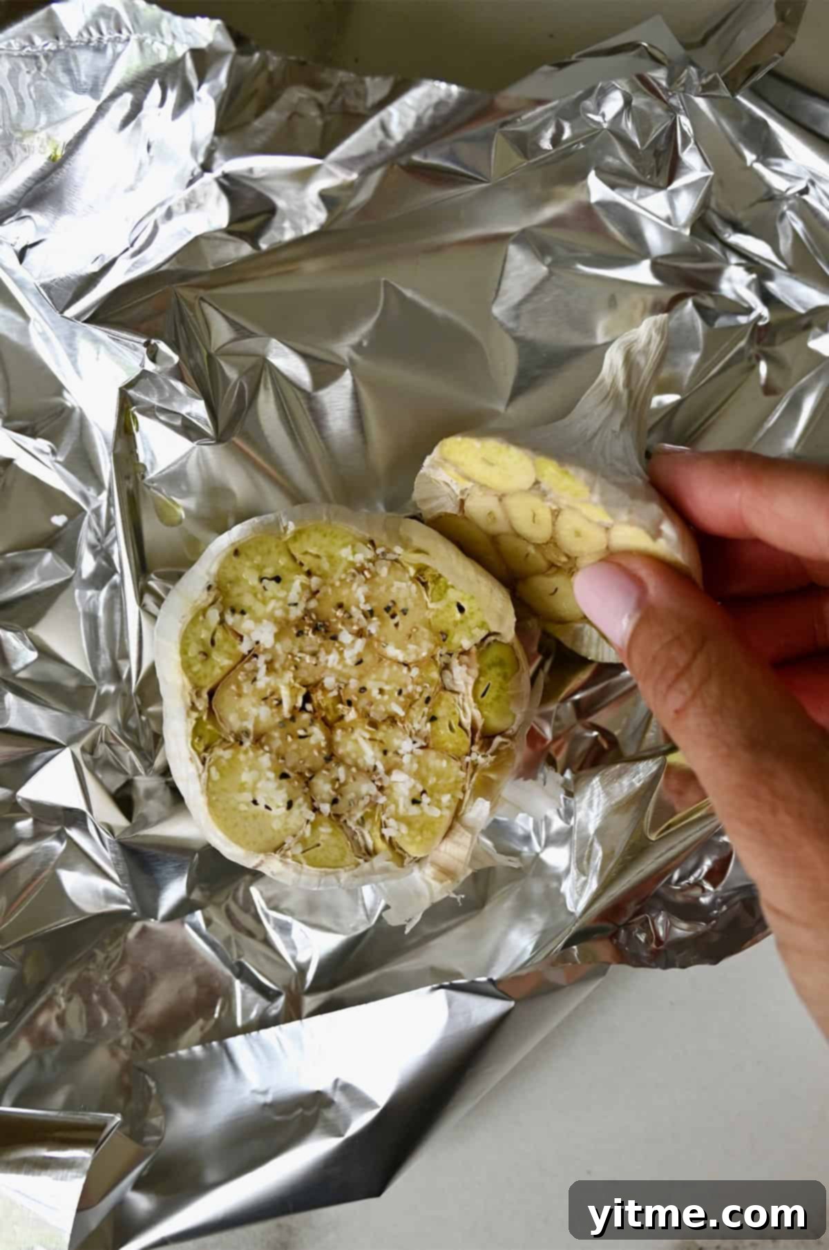 Head of garlic cut in half, drizzled with olive oil, and seasoned with salt and pepper.