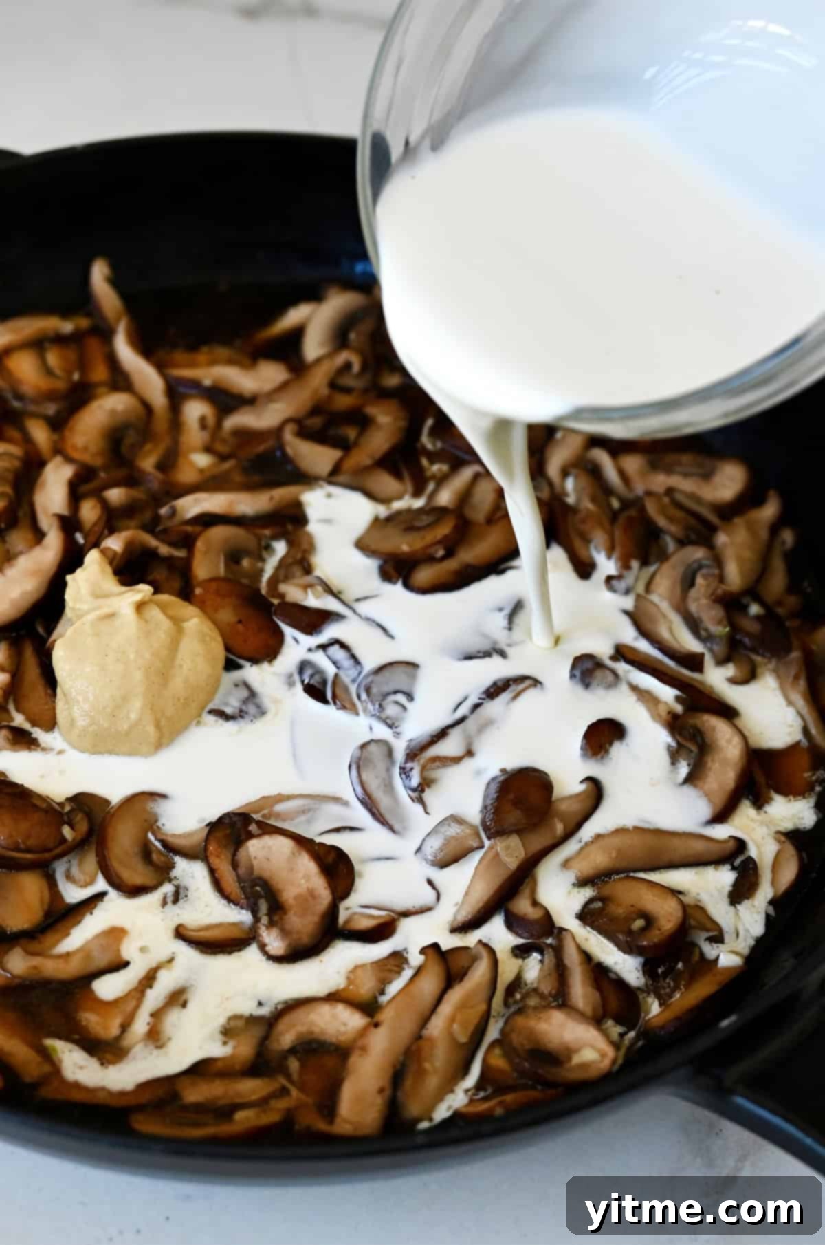 Adding heavy cream to make mushroom cream sauce.