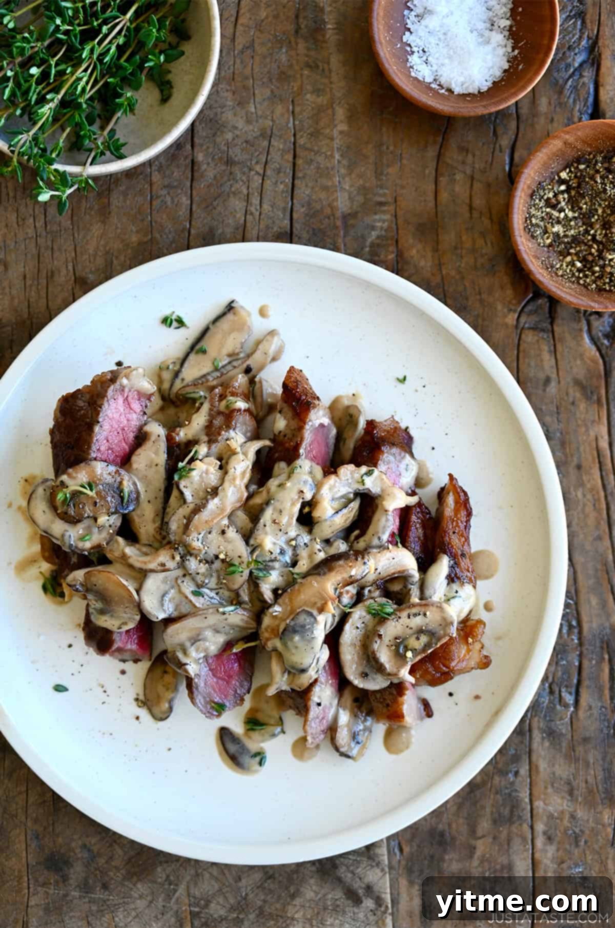 Mushroom sauce over steak on a dinner plate.