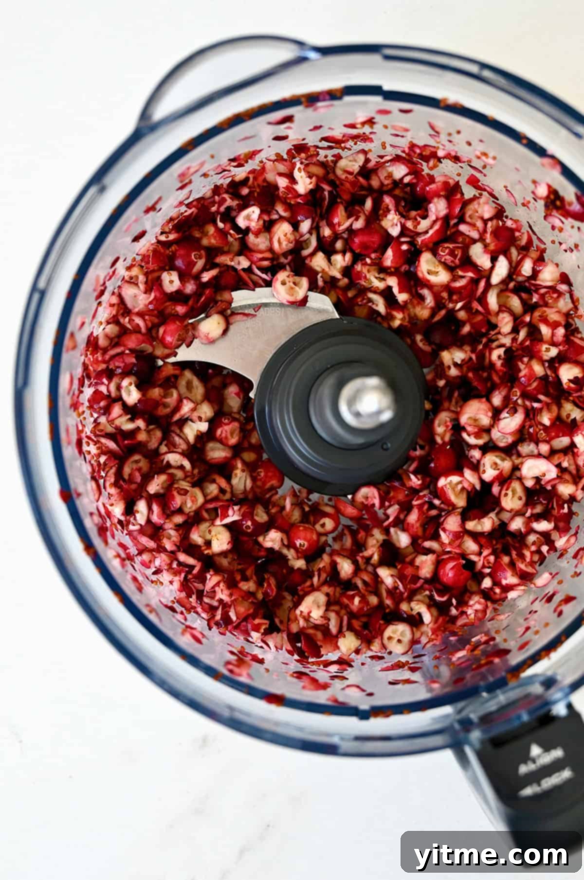 Roughly chopped cranberries in a food processor, the first step to making the perfect cranberry jalapeno dip.