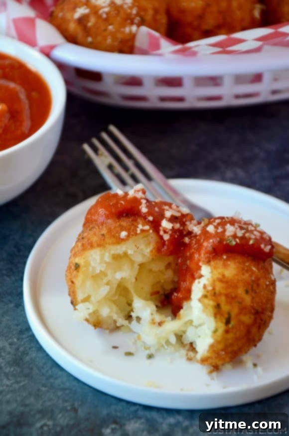 Golden brown Arancini (Rice Balls) served with marinara sauce