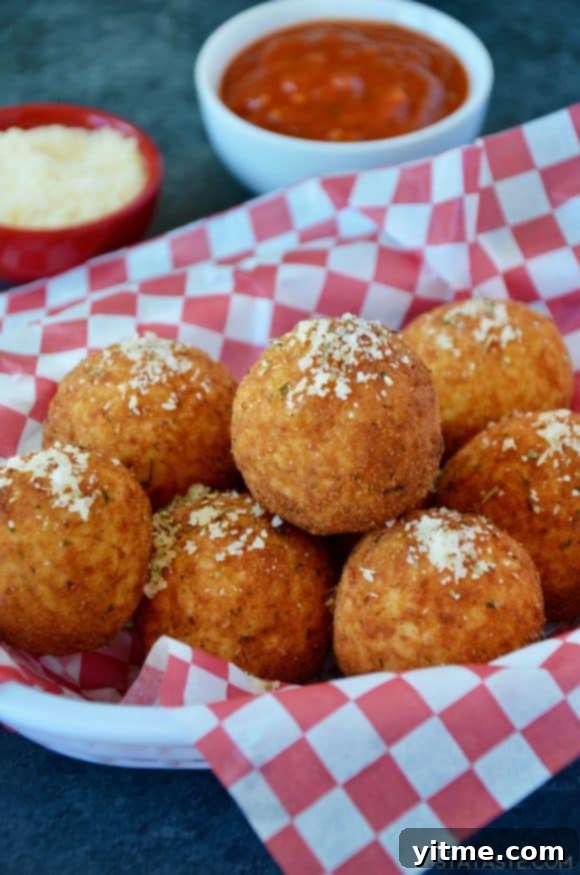 A basket full of delicious arancini rice balls sprinkled with parmesan cheese