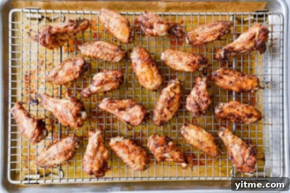 Cooling rack with chicken wings over baking sheet